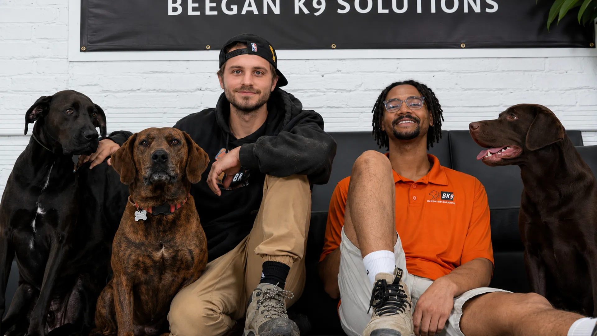 Beegan K9 founders Caden Beegan and Zach Saxton with three dogs at the Cleveland facility